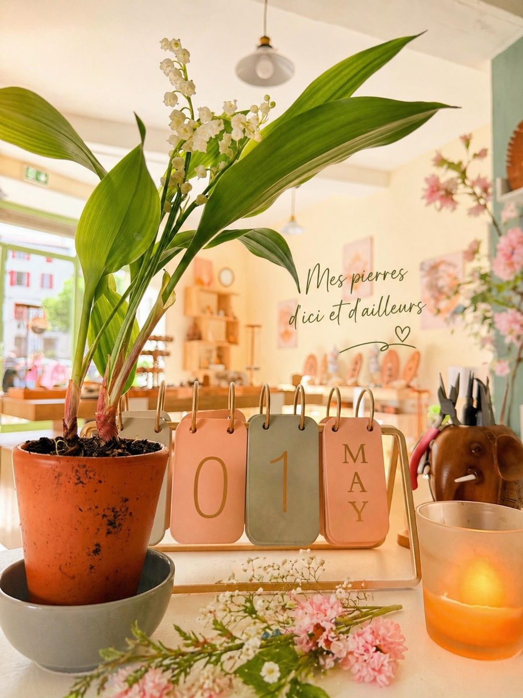 Composition de printemps avec muguet, calendrier et bougie dans la boutique de Carnoules