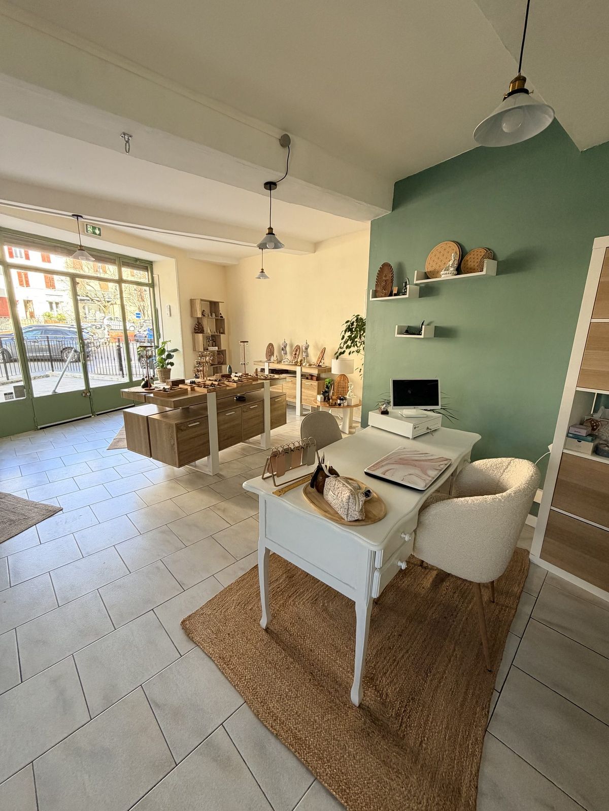 Vue d'ensemble de la boutique de pierres à Carnoules : présentoirs en bois clair, mur vert et tapis de jute